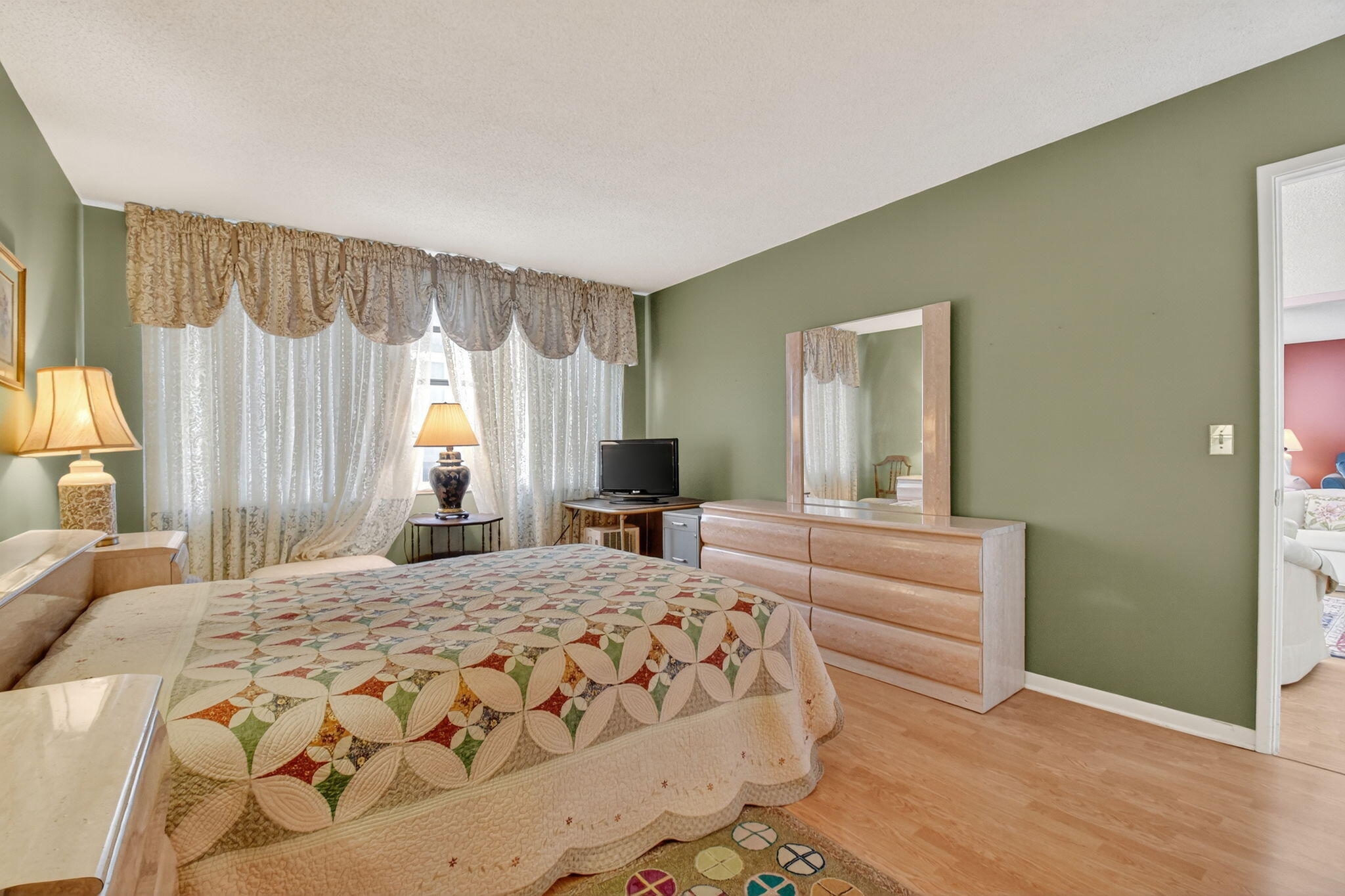 3570 South Ocean Boulevard, Unit 508 South Palm Beach, FL 33480 - Photo 22 of 47 a bedroom with a large bed and a chandelier