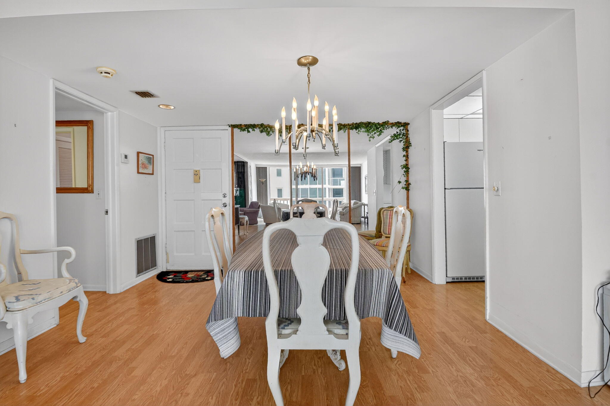 3570 South Ocean Boulevard, Unit 508 South Palm Beach, FL 33480 - Photo 8 of 47 a view of a dining room with furniture a chandelier and wooden floor
