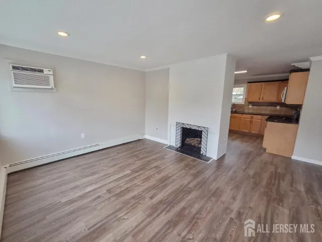 a view of a livingroom with wooden floor and a fireplace