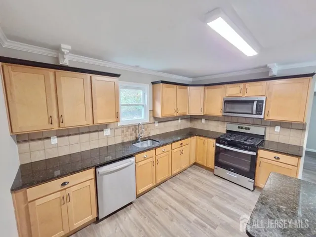 a kitchen with stainless steel appliances granite countertop a stove and a sink