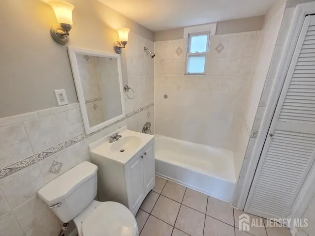 a bathroom with a sink a toilet a mirror and shower