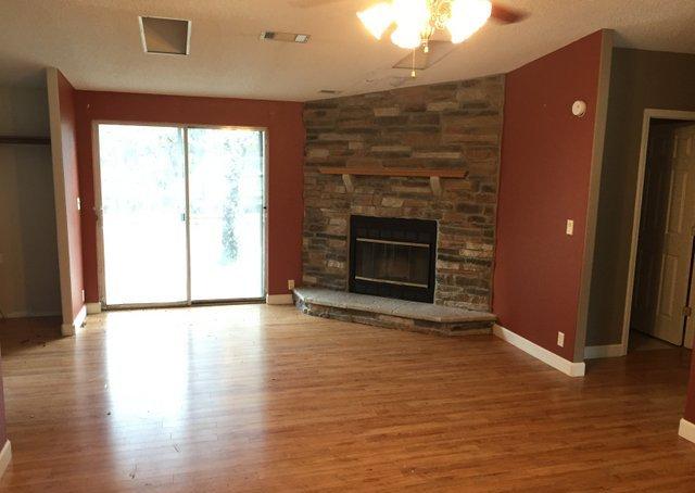 350 Robbins Road DeFuniak Springs, FL 32433 - Photo 2 of 13 an empty room with wooden floor and fireplace