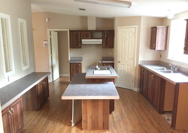 350 Robbins Road DeFuniak Springs, FL 32433 - Photo 4 of 13 a kitchen with a table chairs refrigerator and microwave