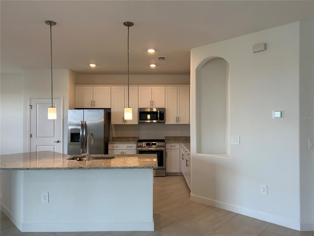 15513 White Linen Drive Lakewood Ranch, FL 34211 - Photo 7 of 35 a kitchen with kitchen island a sink stainless steel appliances and cabinets