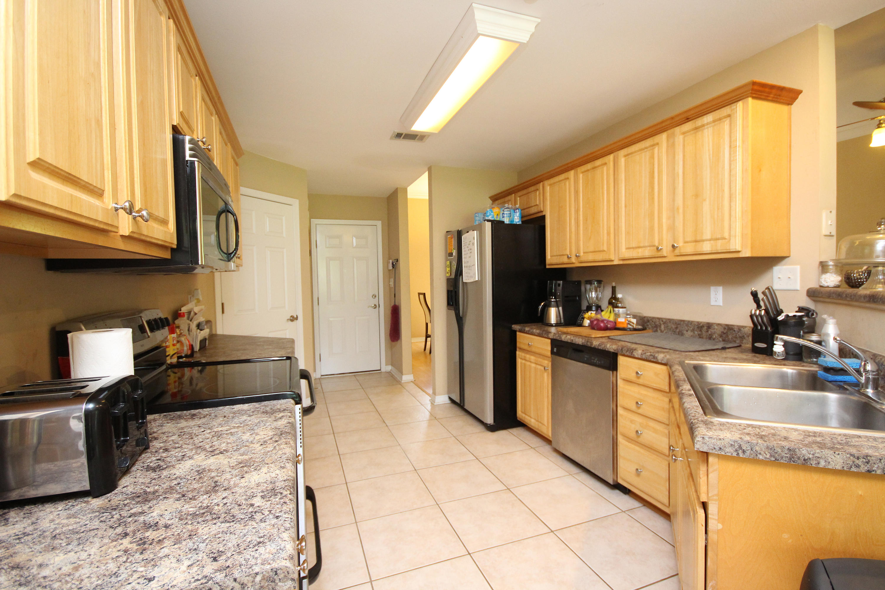 5819 Roberts Road Crestview, FL 32536 - Photo 7 of 36 a kitchen with stainless steel appliances granite countertop a refrigerator a stove top oven a sink a dining table and chairs