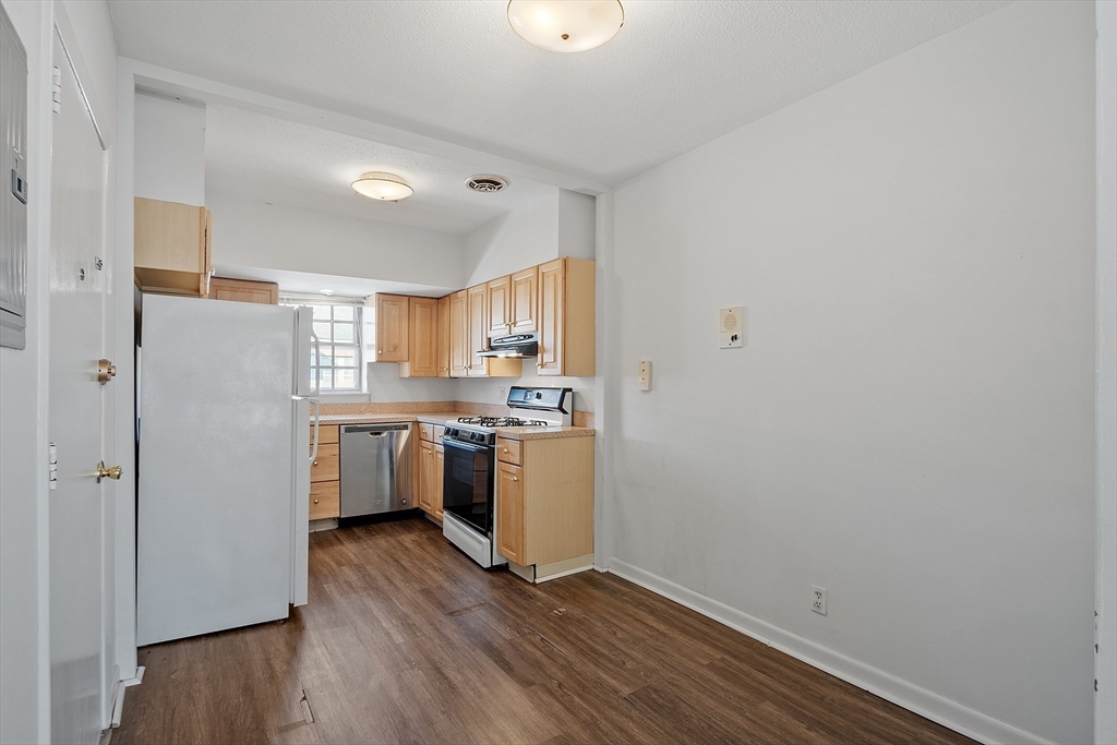 170 Lake Shore Road, Unit 4 Boston, MA 02135 - Photo 3 of 36 a kitchen with a refrigerator sink and cabinets