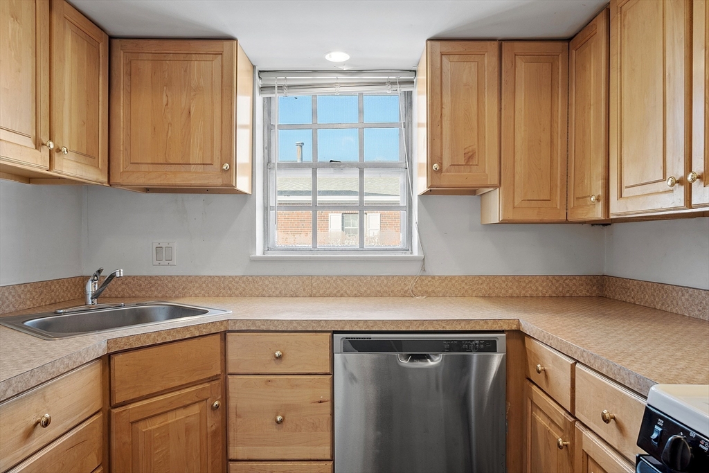 170 Lake Shore Road, Unit 4 Boston, MA 02135 - Photo 7 of 36 a kitchen with granite countertop white cabinets and sink
