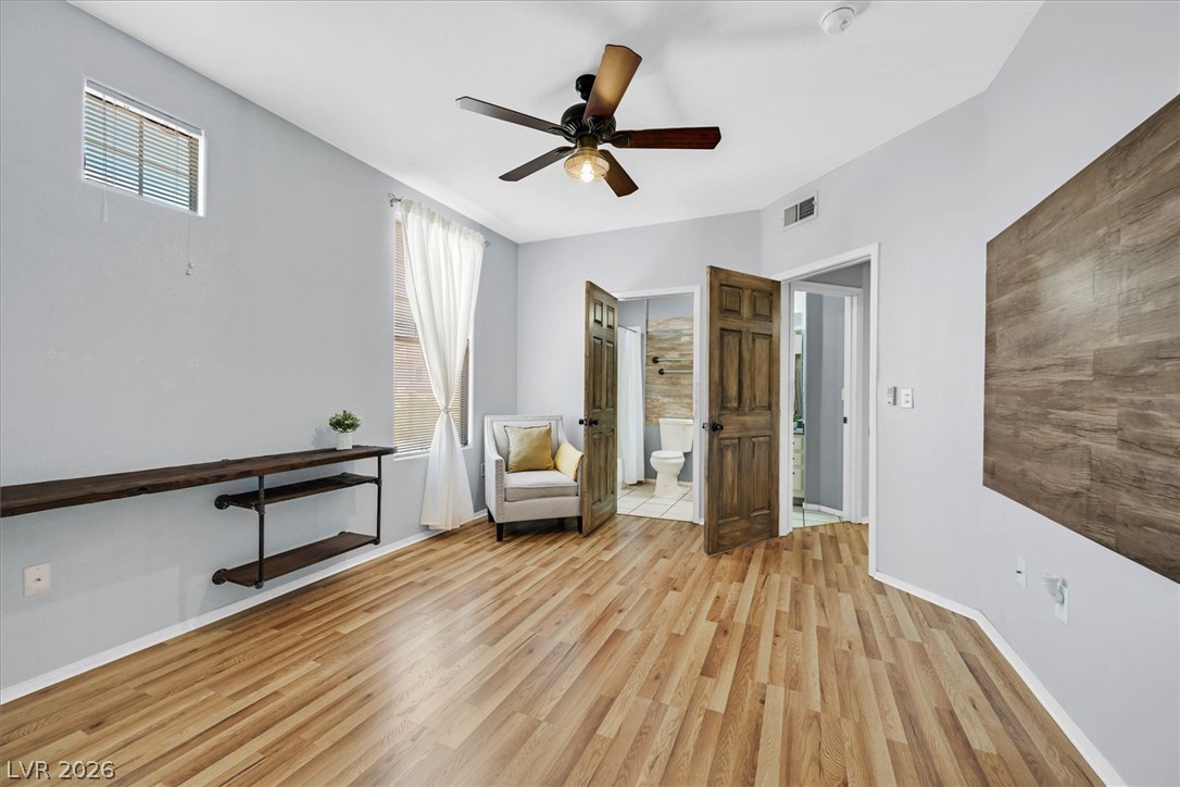 8555 West Russell Road, Unit 2069 Las Vegas, NV 89113 - Photo 14 of 27 A comfortable bedroom with rich wood flooring and a stylish ceiling fan offers direct access to a private bathroom.