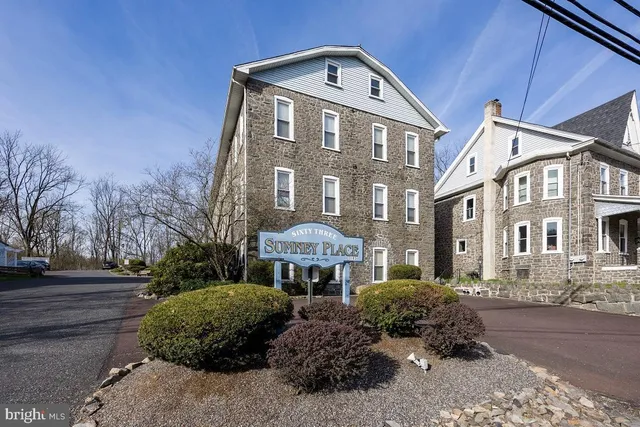 a front view of a residential apartment building with a yard