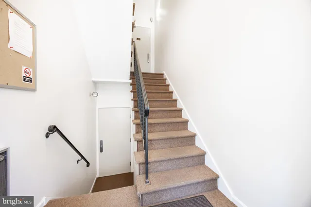 a view of staircase with lots of frames on wall