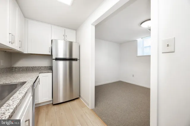 a kitchen with granite countertop a stove top oven a sink and dishwasher