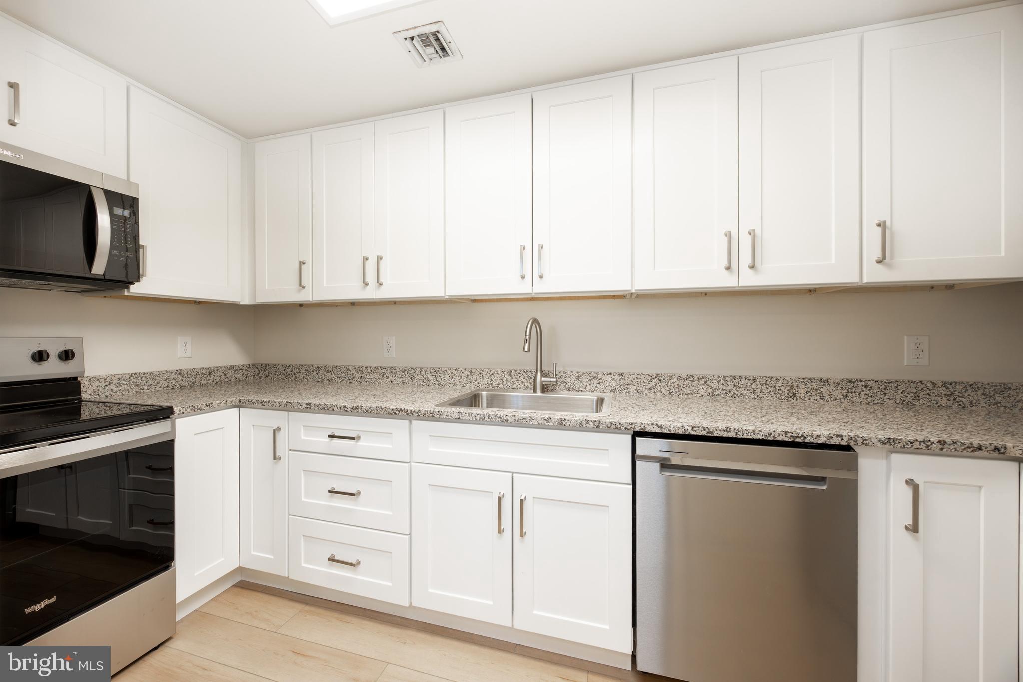 3183 Main Street, Unit 3 Green Lane, PA 18054 - Photo 7 of 28 a kitchen with granite countertop white cabinets and stainless steel appliances