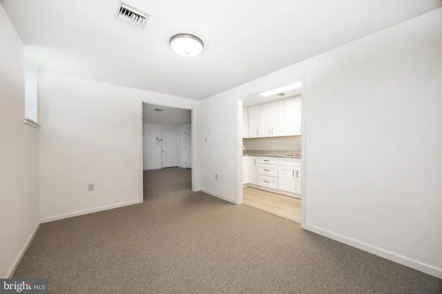 an empty room with a fireplace and cabinet