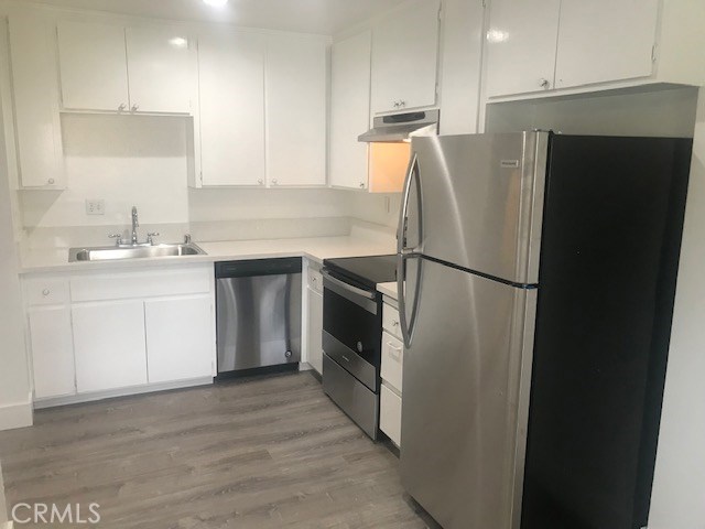 2155 Canyon Drive, Unit A Costa Mesa, CA 92627 - Photo 1 of 10 a kitchen with a refrigerator sink and cabinets