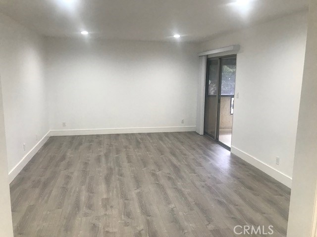 2155 Canyon Drive, Unit A Costa Mesa, CA 92627 - Photo 4 of 10 an empty room with wooden floor and windows