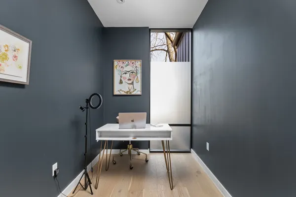 a view of a workspace with furniture and wooden floor
