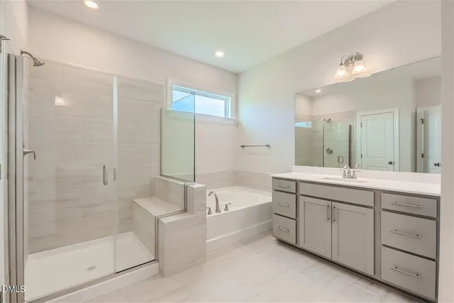 a bathroom with a tub sink shower and mirror