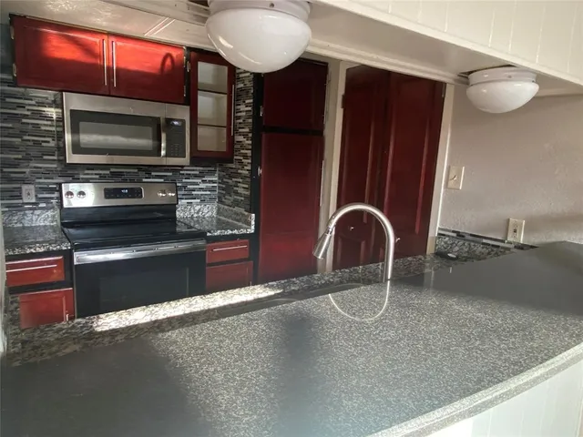 a kitchen with stainless steel appliances granite countertop a sink and a microwave