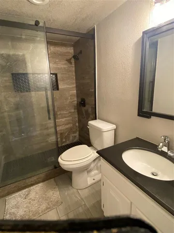 a bathroom with a toilet a sink and shower