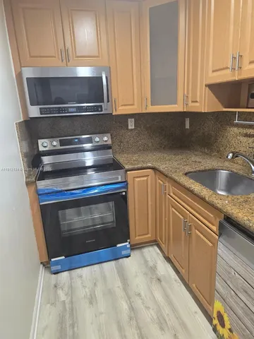a kitchen with granite countertop a stove and a sink