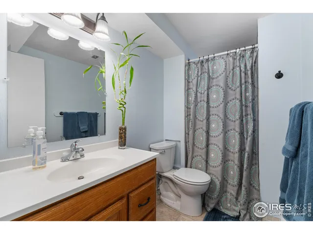 a bathroom with a granite countertop sink a toilet and a mirror
