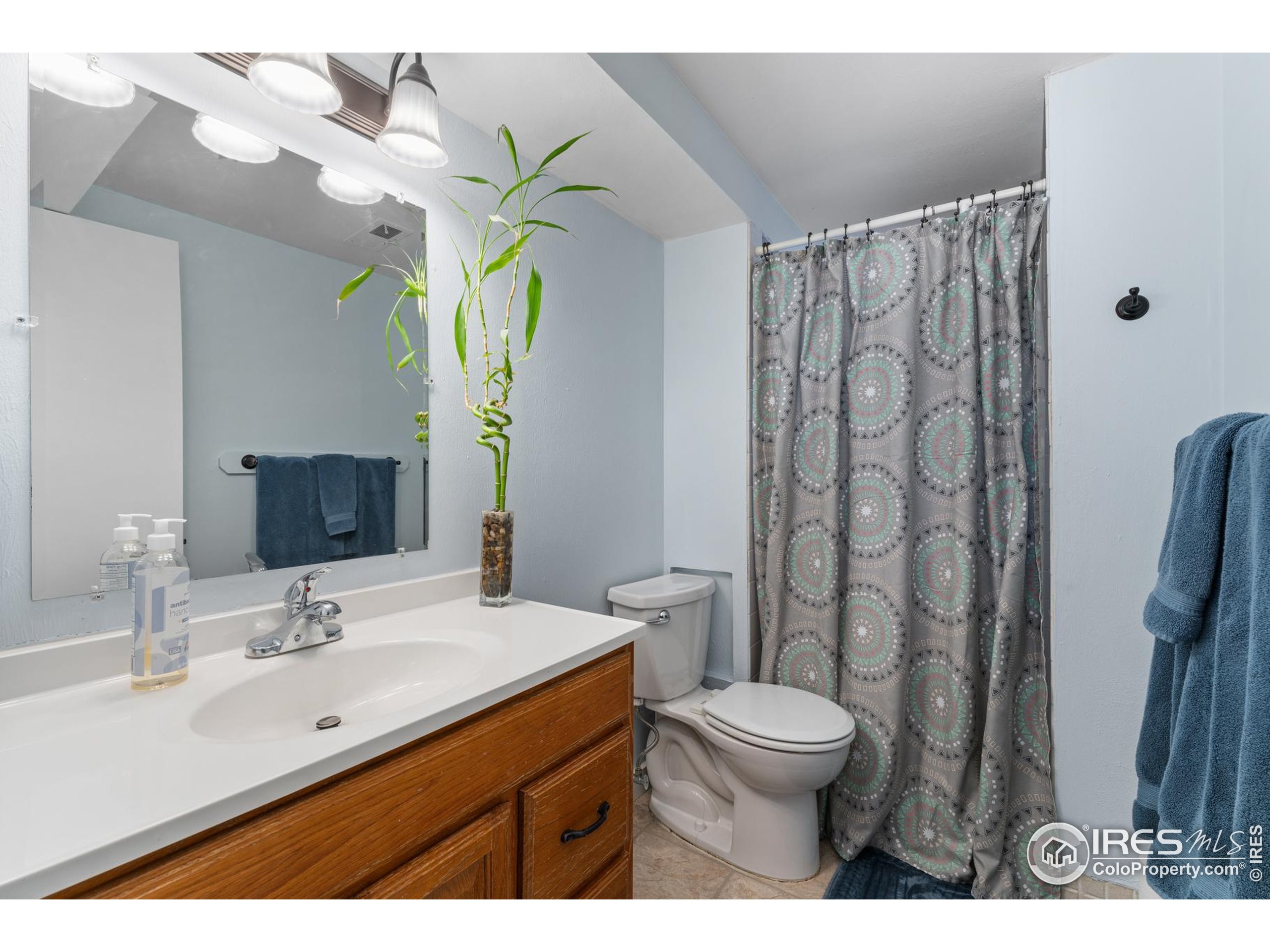 9261 Julian Way Westminster, CO 80031 - Photo 26 of 33 a bathroom with a granite countertop sink a toilet and a mirror