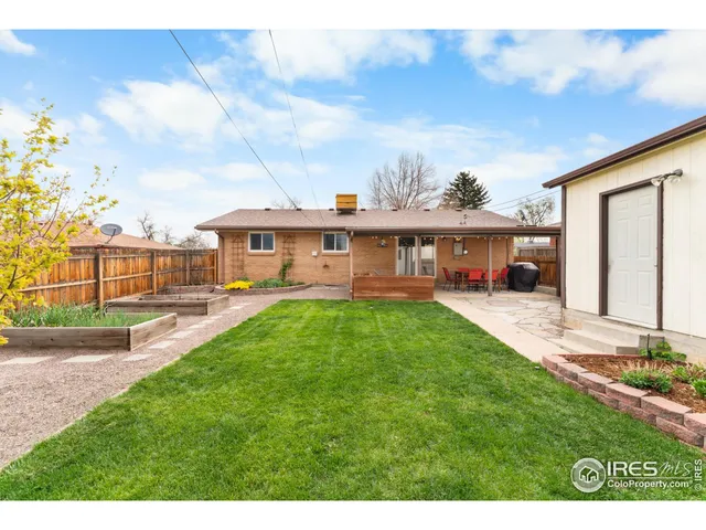 a view of a house with a big yard plants and large trees
