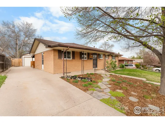a view of a white house with a large tree