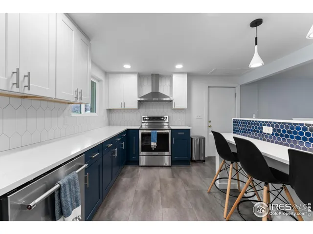 a kitchen with granite countertop a sink cabinets and stainless steel appliances