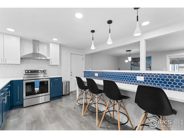 a kitchen with stainless steel appliances kitchen island granite countertop a stove a sink a dining table and chairs