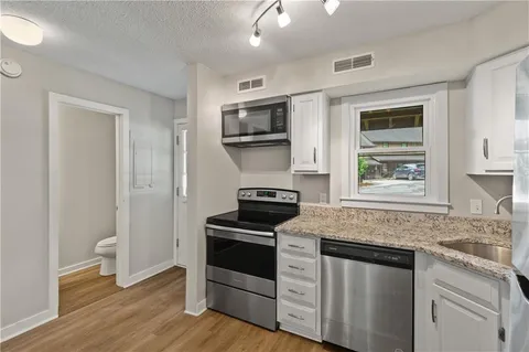 a kitchen with stainless steel appliances granite countertop a stove and a microwave