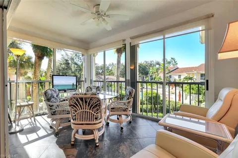 a living room with furniture and a floor to ceiling window