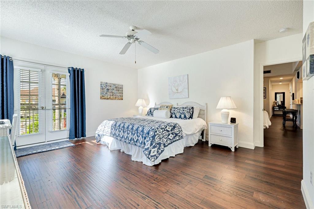 109 Tuscana Court, Unit 308 Naples, FL 34119 - Photo 8 of 18 a spacious bedroom with a large bed and a wooden floor
