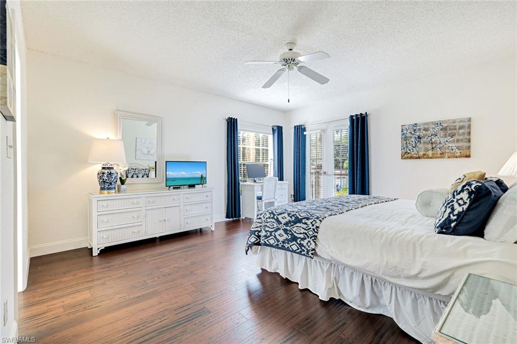 109 Tuscana Court, Unit 308 Naples, FL 34119 - Photo 9 of 18 a bedroom with a bed a couch and dresser