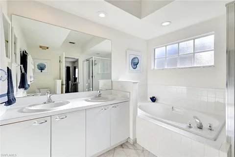a bathroom with a tub a sink and mirror