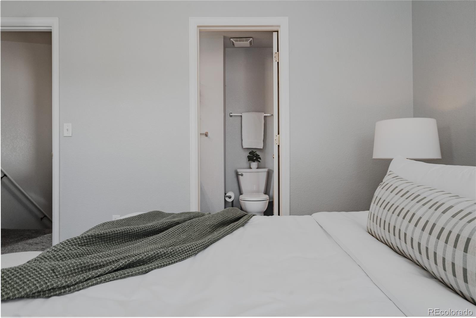 5081 Garrison Street, Unit 9 Wheat Ridge, CO 80033 - Photo 19 of 31 a bedroom with a bed and a mirror