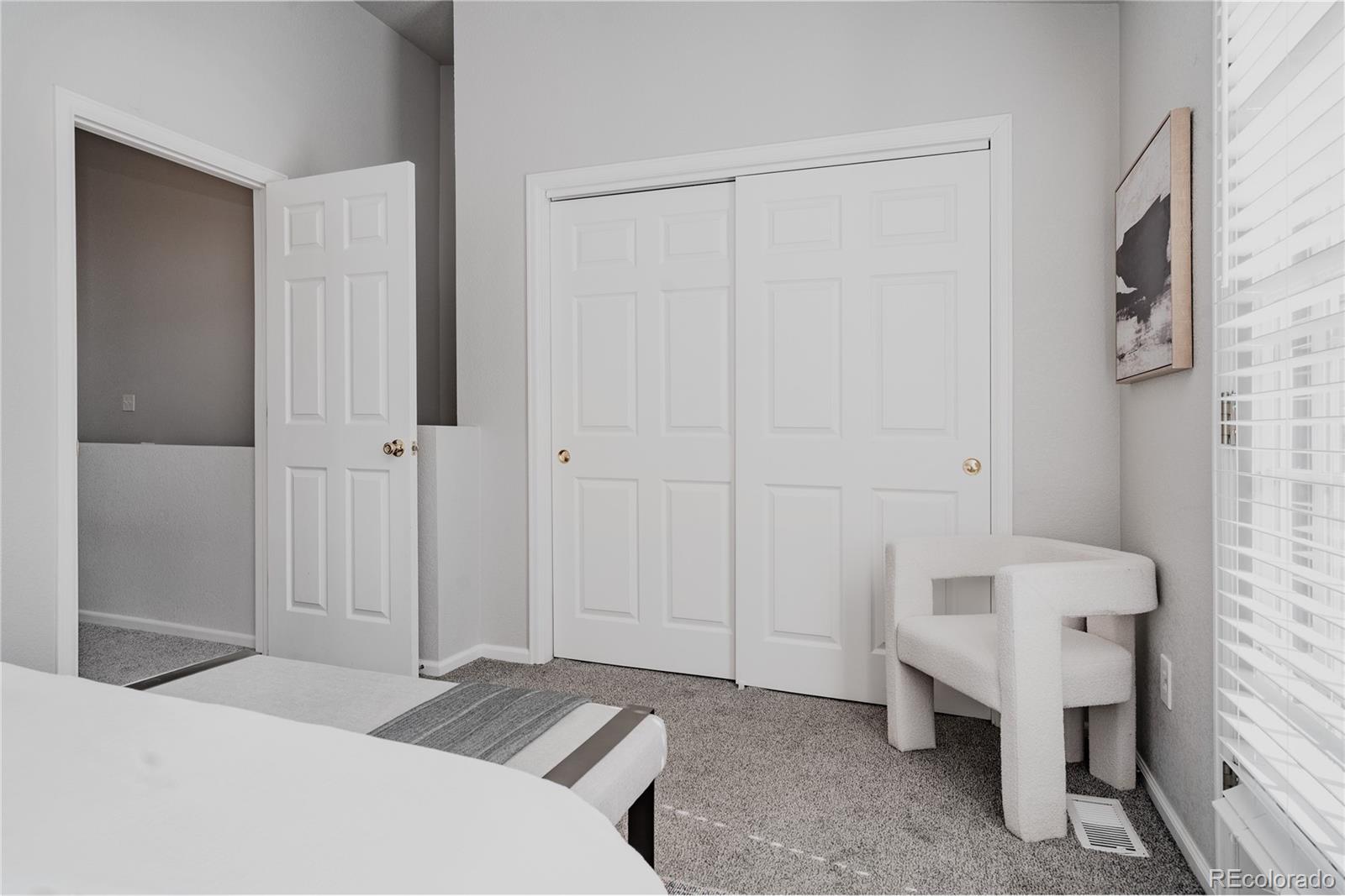 5081 Garrison Street, Unit 9 Wheat Ridge, CO 80033 - Photo 24 of 31 a bedroom with a bed and a chair