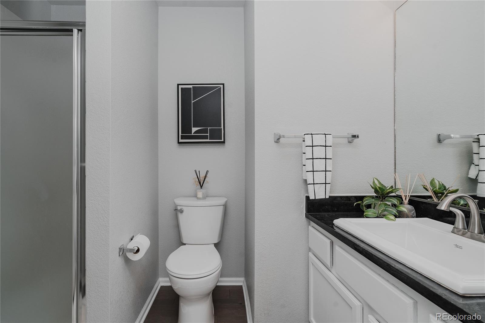 5081 Garrison Street, Unit 9 Wheat Ridge, CO 80033 - Photo 26 of 31 a bathroom with a sink toilet and a mirror