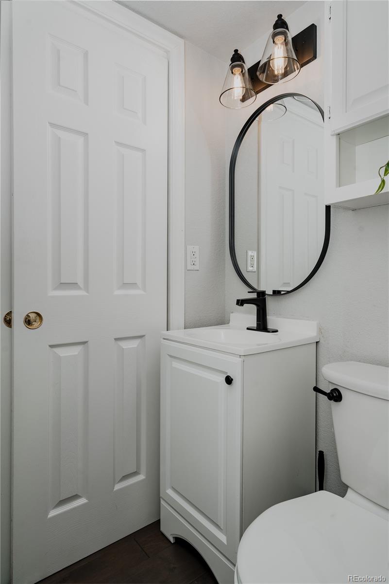 5081 Garrison Street, Unit 9 Wheat Ridge, CO 80033 - Photo 3 of 31 a bathroom with a sink a toilet and a mirror