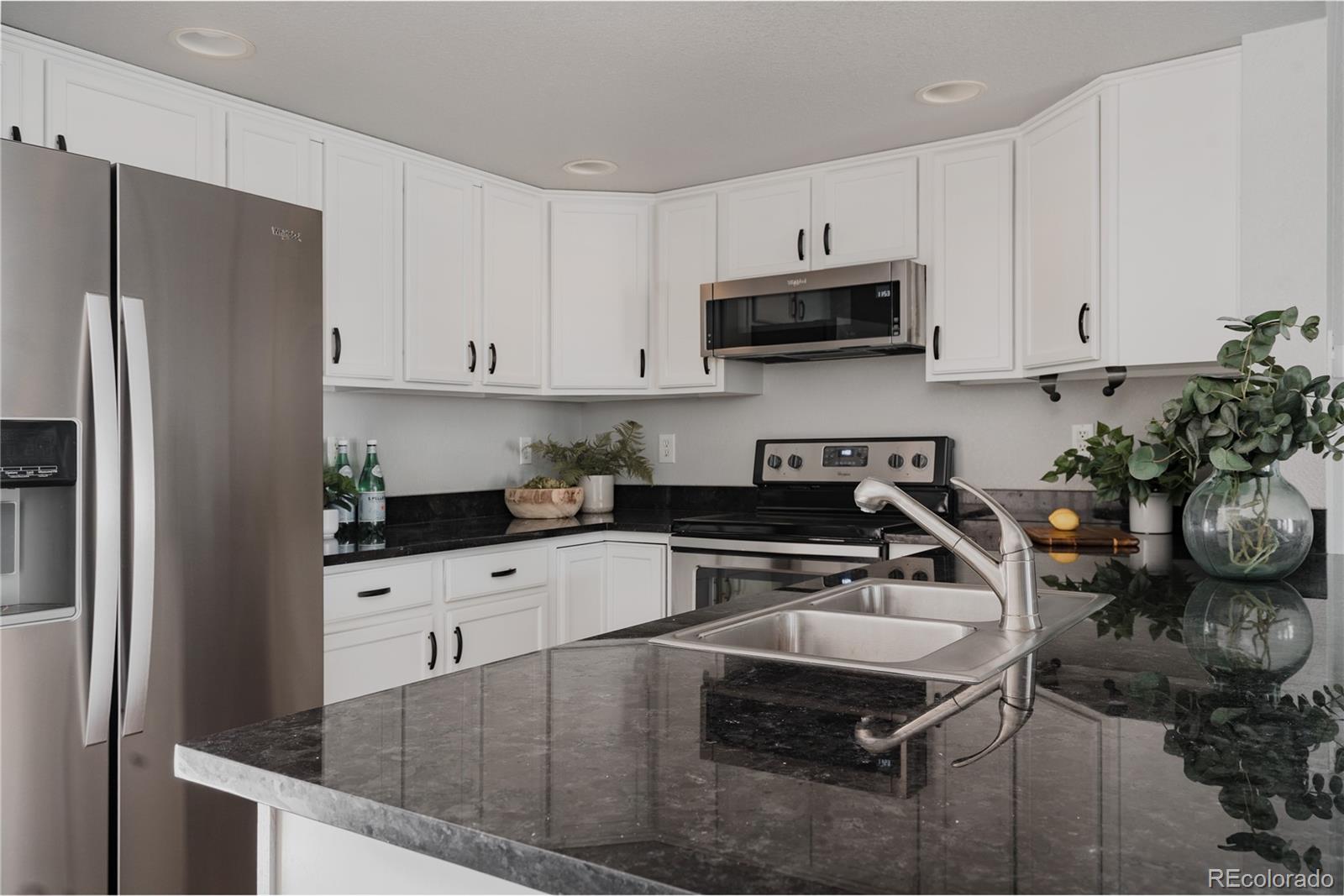 5081 Garrison Street, Unit 9 Wheat Ridge, CO 80033 - Photo 5 of 31 a kitchen with granite countertop a sink stove and refrigerator