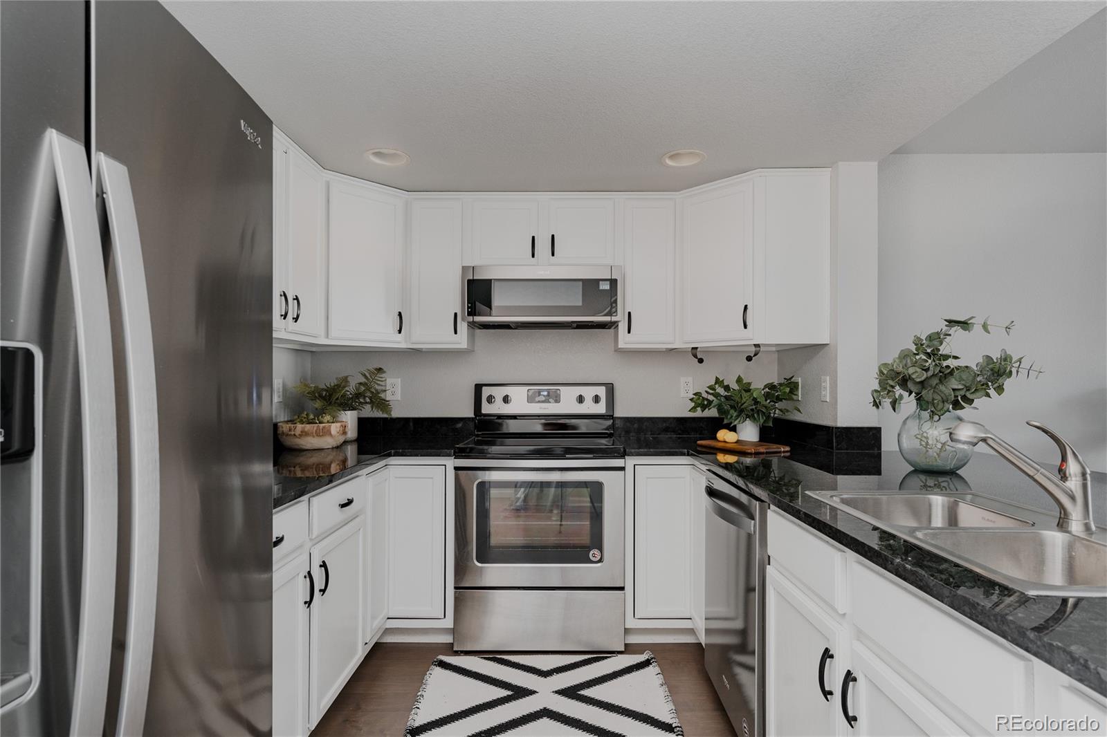 5081 Garrison Street, Unit 9 Wheat Ridge, CO 80033 - Photo 6 of 31 a kitchen with a stove and white cabinets