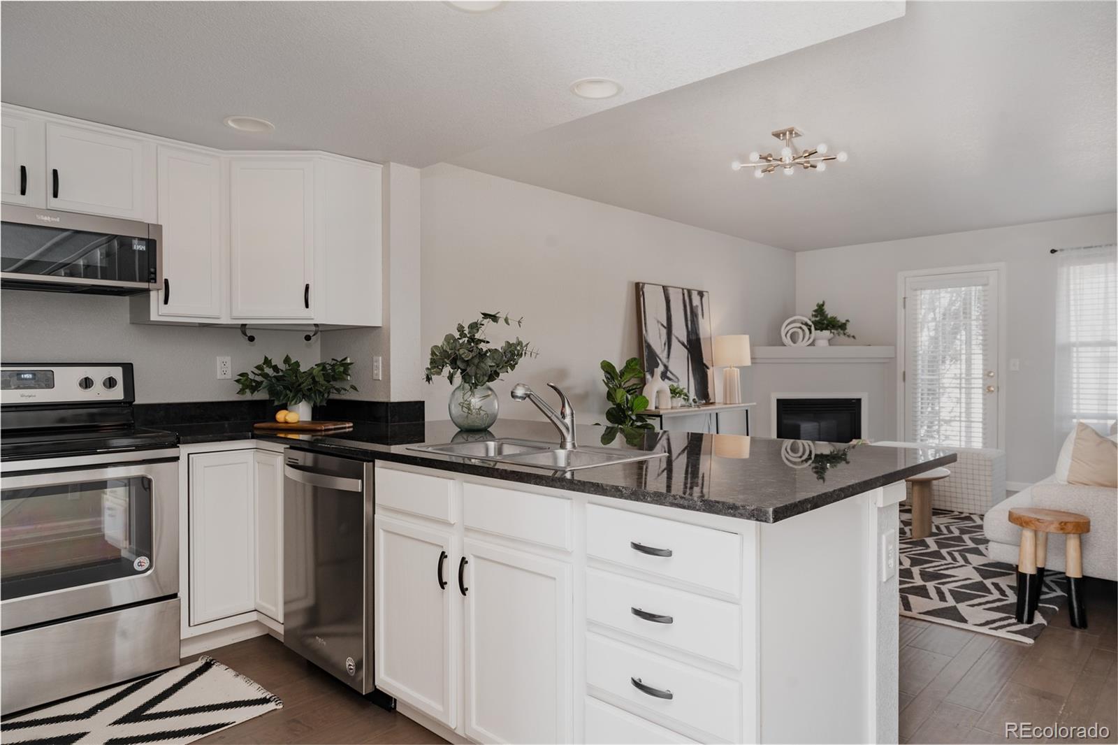 5081 Garrison Street, Unit 9 Wheat Ridge, CO 80033 - Photo 7 of 31 a kitchen with granite countertop white cabinets and white appliances