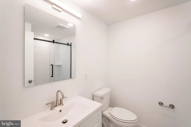 a bathroom with a sink a toilet and mirror