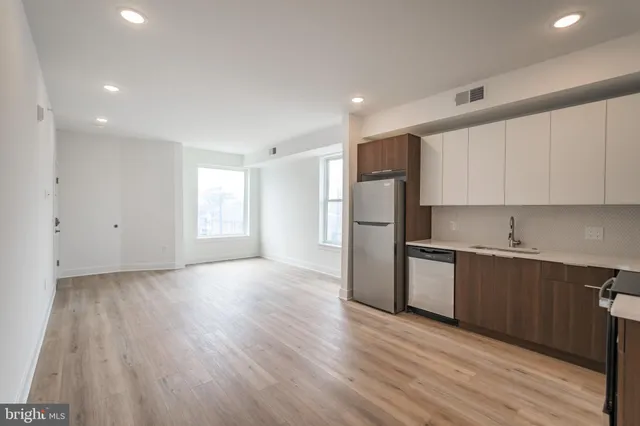 a kitchen with refrigerator cabinets and wooden floor