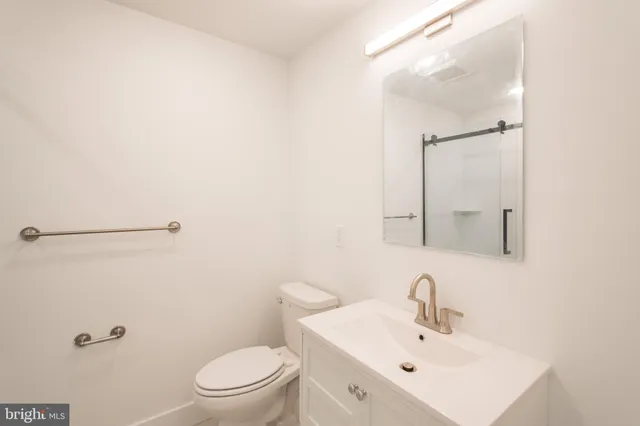 a bathroom with a sink a toilet and a mirror