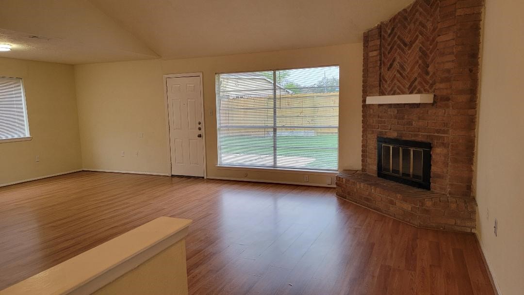 3319 Boxelder Drive Houston, TX 77082 - Photo 3 of 9 an empty room with wooden floor fireplace and windows