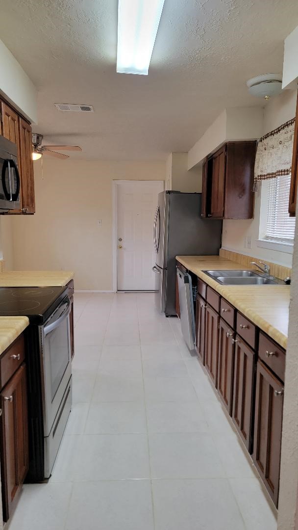 3319 Boxelder Drive Houston, TX 77082 - Photo 5 of 9 a kitchen with stainless steel appliances a stove a sink and a refrigerator