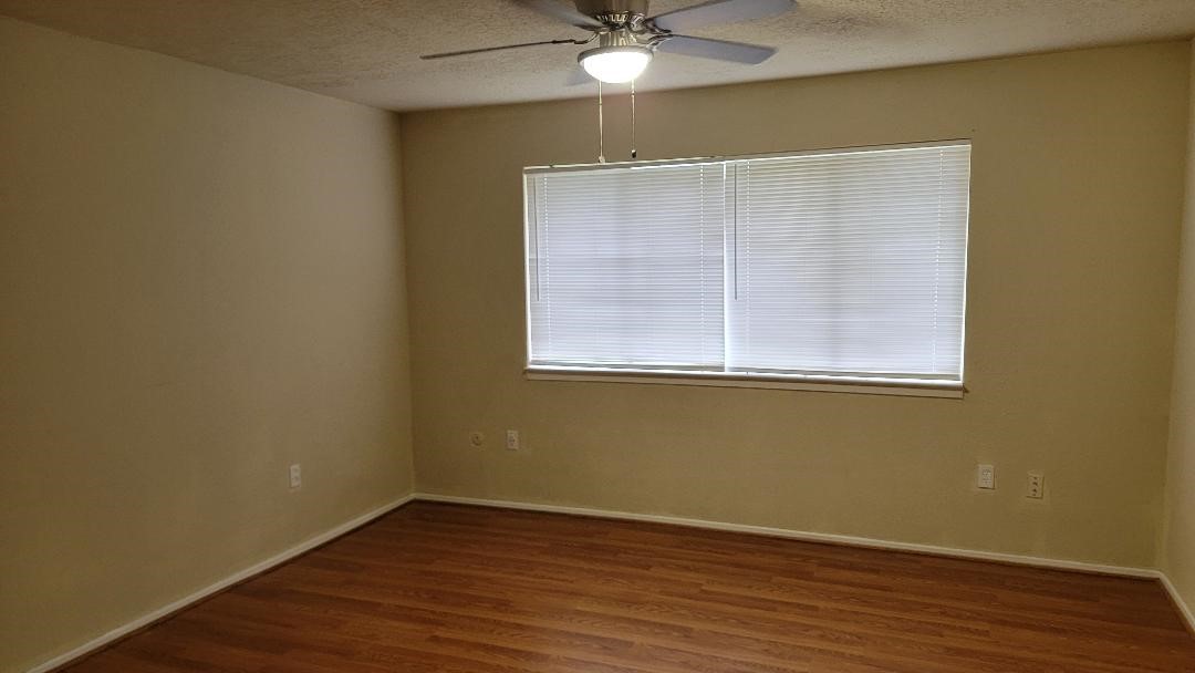 3319 Boxelder Drive Houston, TX 77082 - Photo 6 of 9 an empty room with wooden floor and windows