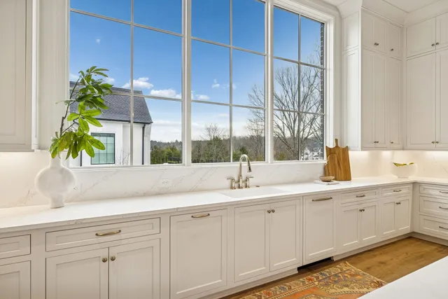 a view of a house with large windows and wooden fence
