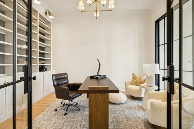 a kitchen with kitchen island granite countertop a wooden floor and white cabinets